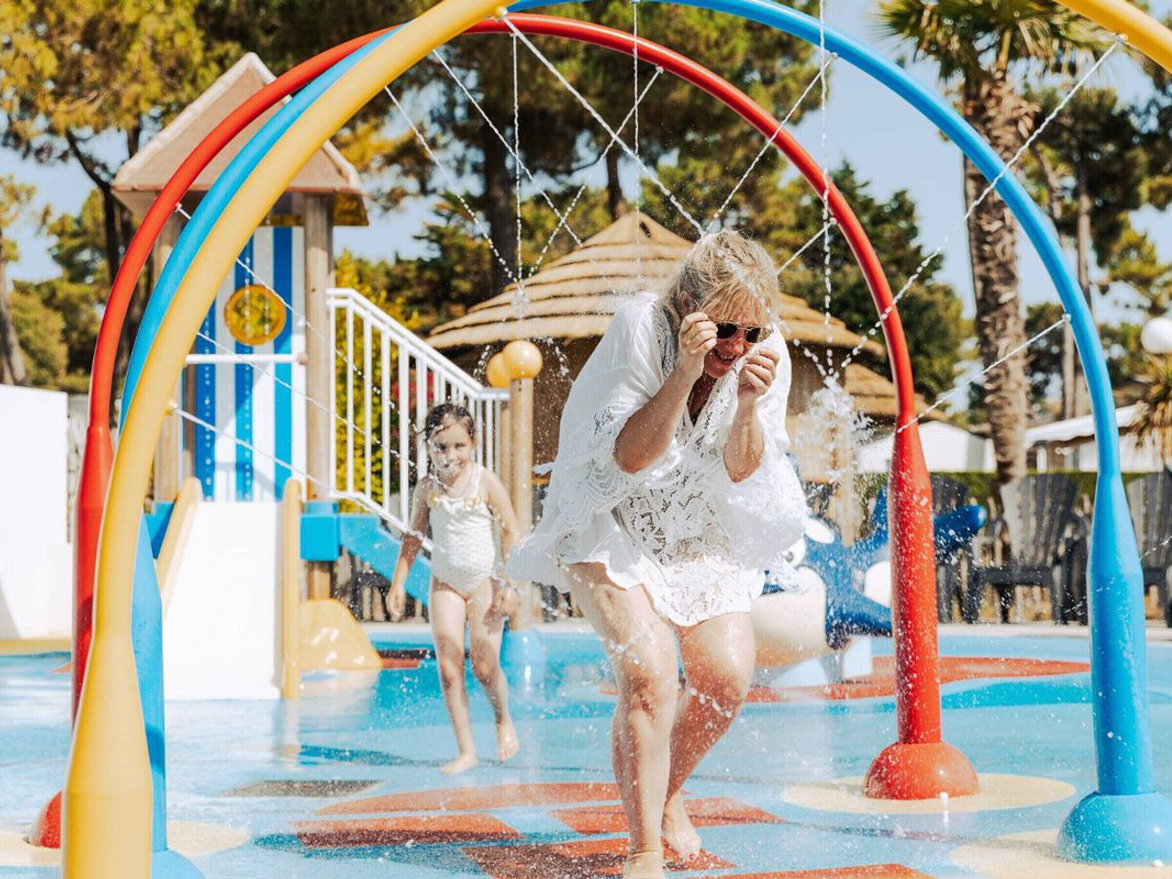 Parque acuático con una estructura de arco de colores y una zona de juegos.