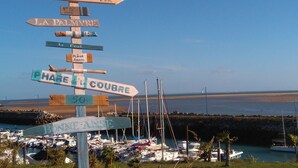 A directional signpost with multiple arrows pointing to various destinations, including 'Cote Sauvage' and 'La Palmyre.' - Renovated Villa in La Palmyre - Sleeps 6 - Air Conditioning - Wifi - Parking (La Palmyre)