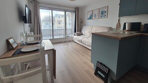 Een modern appartement met een eethoek, een bank en een keuken.