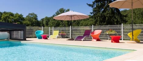 A swimming pool with colorful lounge chairs and umbrellas.
