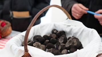 A basket filled with dark-colored items, possibly food, on a table with a checkered tablecloth.