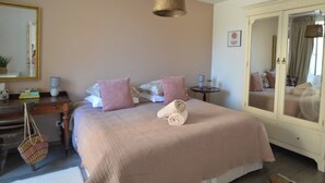 Une chambre à coucher comprenant un lit, une table de chevet, un miroir et une armoire.