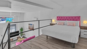 A modern bedroom with a large bed, a pink headboard, and a balcony with a pink bench. - Modern Apartment in Málaga (Málaga)