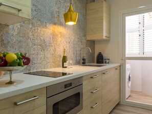 A modern kitchen with a built-in oven, a sink, and a fruit bowl on the counter. - Elegant apartment in Malaga city center, close to the beach (Málaga)