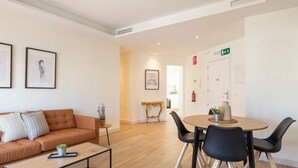 Ein modernes Wohnzimmer mit einer Couch, einem Couchtisch und einem Essbereich mit Stühlen.