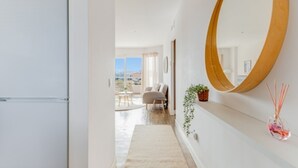 A modern hallway with a large mirror, a plant, and a view of a dining area. - Torremolinos: Family relaxation with a lovely terrace. (Torremolinos)