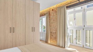 Un dormitorio con un armario grande, una cama y vistas a través de un ventanal.