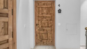 Una puerta de madera con un ojo de cerradura, un buzón y el número 4 en la pared.