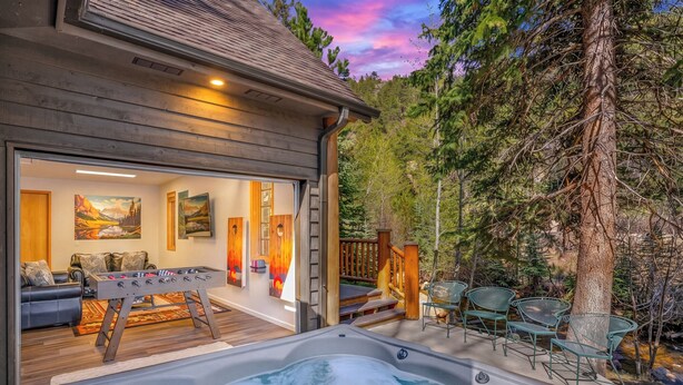 Une cabane en bois avec un jacuzzi, un espace salon extérieur et une cheminée.