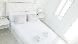 A modern, minimalist bedroom with a large bed, white bedding, and a clean, bright design. - Seafront apartment with pool in Benalmádena (Benalmádena)