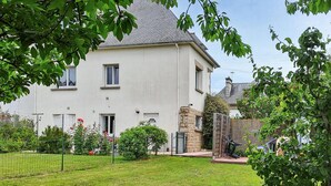 A two-story house with a well-maintained lawn and a stone wall. - 3 bedroom amazing home in Cancale (Cancale)