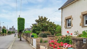 A street with stone walls, a row of houses, and a church in the background. - 3 bedroom amazing home in Cancale (Cancale)