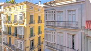 Un edificio de varios pisos con balcones y ventanas grandes.