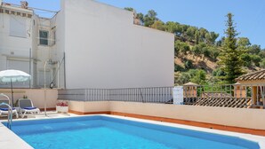A rectangular swimming pool with clear blue water, surrounded by a white wall and a metal railing. - Charming Apt in the heart of Malaga with rooftop pool (Málaga)