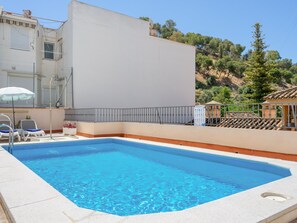 A rectangular swimming pool with clear blue water, surrounded by a white wall and a metal railing. - Charming Apt in the heart of Malaga with rooftop pool (Málaga)
