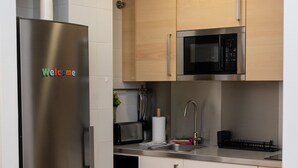 Una cucina moderna con elettrodomestici in acciaio inossidabile, tra cui un frigorifero e un forno a microonde.