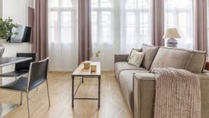 Una sala de estar moderna con un sofá, una mesa de centro y un televisor montado en la pared.