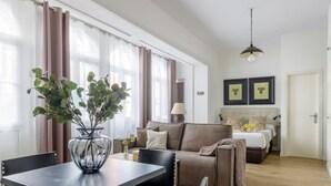Una sala de estar moderna con comedor, que incluye un sofá, una mesa de centro y una mesa de comedor con sillas.