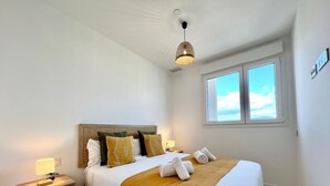 A bedroom with a bed, bedside tables, a window, and a hanging light fixture. - Elegant Accommodation in Malaga - Ideal for Groups (Málaga)