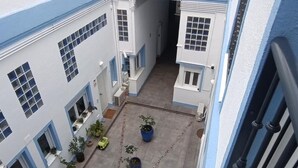 A courtyard with potted plants, a yellow toy car, and a chain-link fence. - Charming apartment in Malaga (Málaga)