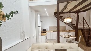 A modern interior with a sofa, a dining area, and a staircase. - Charming apartment in Malaga (Málaga)