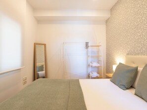 Een hotelkamer met een bed, een douche en een spiegel.
