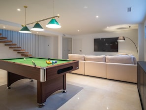 A modern living room with a pool table, a sofa, and a TV. - Luxury Villa in Mijas (Mijas)