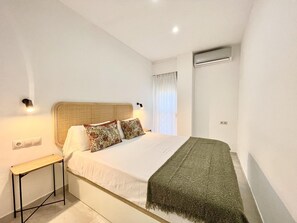 A bedroom with a bed, bedside table, and an air conditioning unit. - Central Malaga Apartment with Wi-Fi (Málaga)