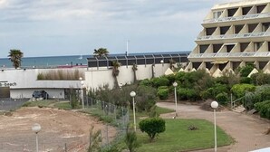 Een kusthotel met een modern design, met een opvallend gebouw dat een geometrisch gevelontwerp heeft en uitzicht op het strand.