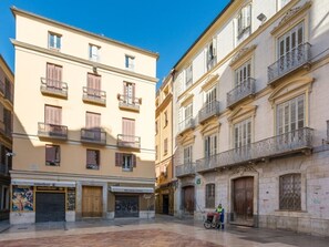 A building with multiple floors, balconies, and a ground-level storefront. - Modern Apartment in the Heart of Malaga (Málaga)