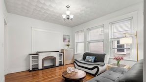 Un salon avec une cheminée, un canapé, une table basse et une lampe.