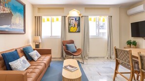 Uma sala de estar moderna com um sofá de couro marrom, uma mesa de centro de madeira e um espaço de jantar com uma mesa e cadeiras de madeira.