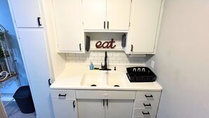 A small kitchen with white cabinets, a sink, and a countertop. - Comfortable Westerville Apt by State Street - Great for Mid-Term, Prime Location (Westerville)