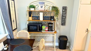 A compact kitchen with a microwave, coffee maker, and a small shelf with kitchen items. - Comfortable Westerville Apt by State Street - Great for Mid-Term, Prime Location (Westerville)