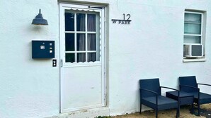 A white building with a white door, a mailbox, and a number '12' sign. - Comfortable Westerville Apt by State Street - Great for Mid-Term, Prime Location (Westerville)