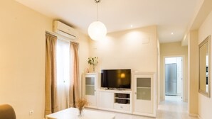 A modern living room with a sofa, a coffee table, a TV, and a cabinet. - Bright 3-bedroom apartment in the heart of Málaga (Málaga)