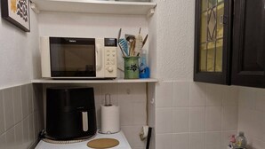 Eine kleine Küche mit Mikrowelle, Kaffeemaschine und kleinem Kühlschrank.