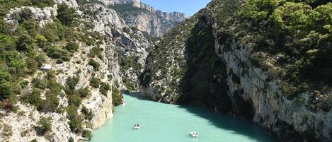 A narrow canyon with turquoise water and rocky cliffs.