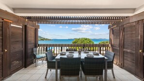 An outdoor dining area with a view of the sea and hills. - Oceanfront, Sapphire Beach, Pool, 2 bedrooms, 2 bath (St. Thomas)