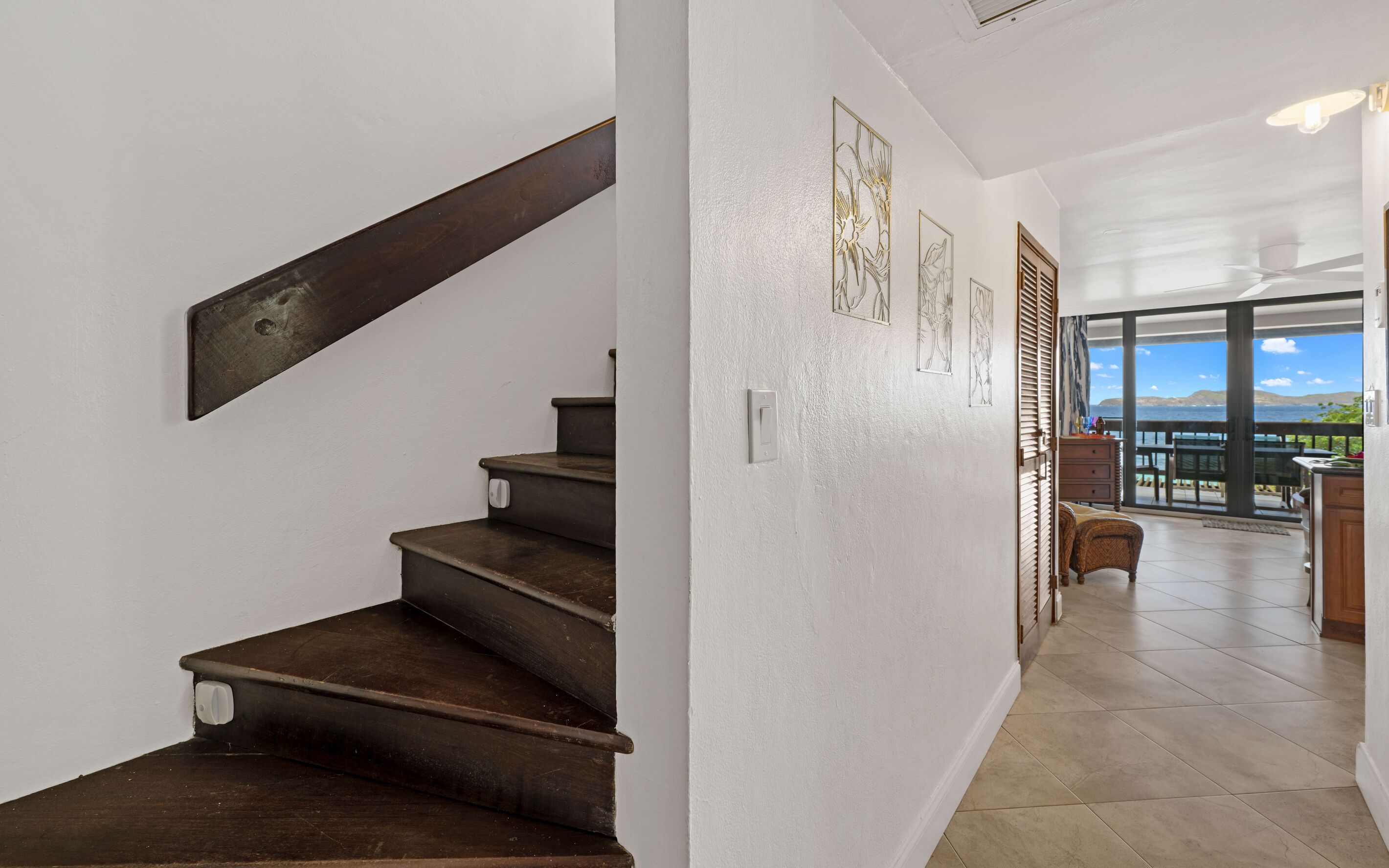 A staircase leading to a balcony with a view of the sea.
