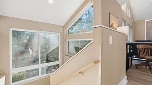 A staircase with a wooden handrail leading to a landing with a desk and chair. - Latitude 45 - forest retreat near Manzanita beach (Manzanita)
