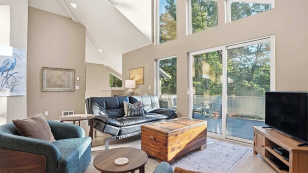 A spacious living room with a leather sofa, a wooden coffee table, and a television. - Latitude 45 - forest retreat near Manzanita beach (Manzanita)