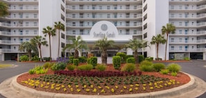Ein mehrstöckiges Hotel mit einem zentralen Schild, auf dem 'Sterling Sands' steht.
