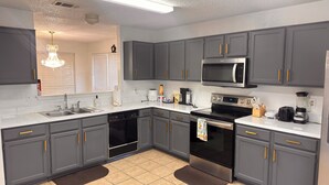A modern kitchen with grey cabinets, a stainless steel microwave, a dishwasher, and a stove. - Your Arlington Hotspot: Games, Flights & Family Fun (Arlington)