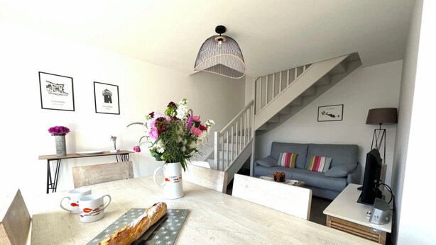 Una cocina moderna con encimera de madera, un jarrón de flores y una hogaza de pan.
