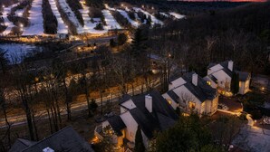 Ein Wohngebiet mit Häusern, einer Straße und einer verschneiten Landschaft im Abenddämmerung.