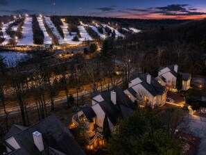 Ein Wohngebiet mit Häusern, einer Straße und einer verschneiten Landschaft im Abenddämmerung.