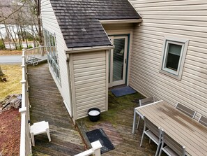 A deck with a table and chairs, a small porch area, and a door leading to a garage. - Mystic  Retreat | Hot Tub & Lake Harmony Access (Lake Harmony)
