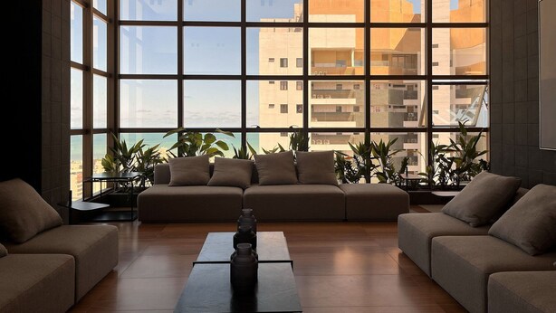 A modern living room with a large window, a sofa, and a coffee table. - Flat Quality Comfort CoHouse - Tambaú (João Pessoa)