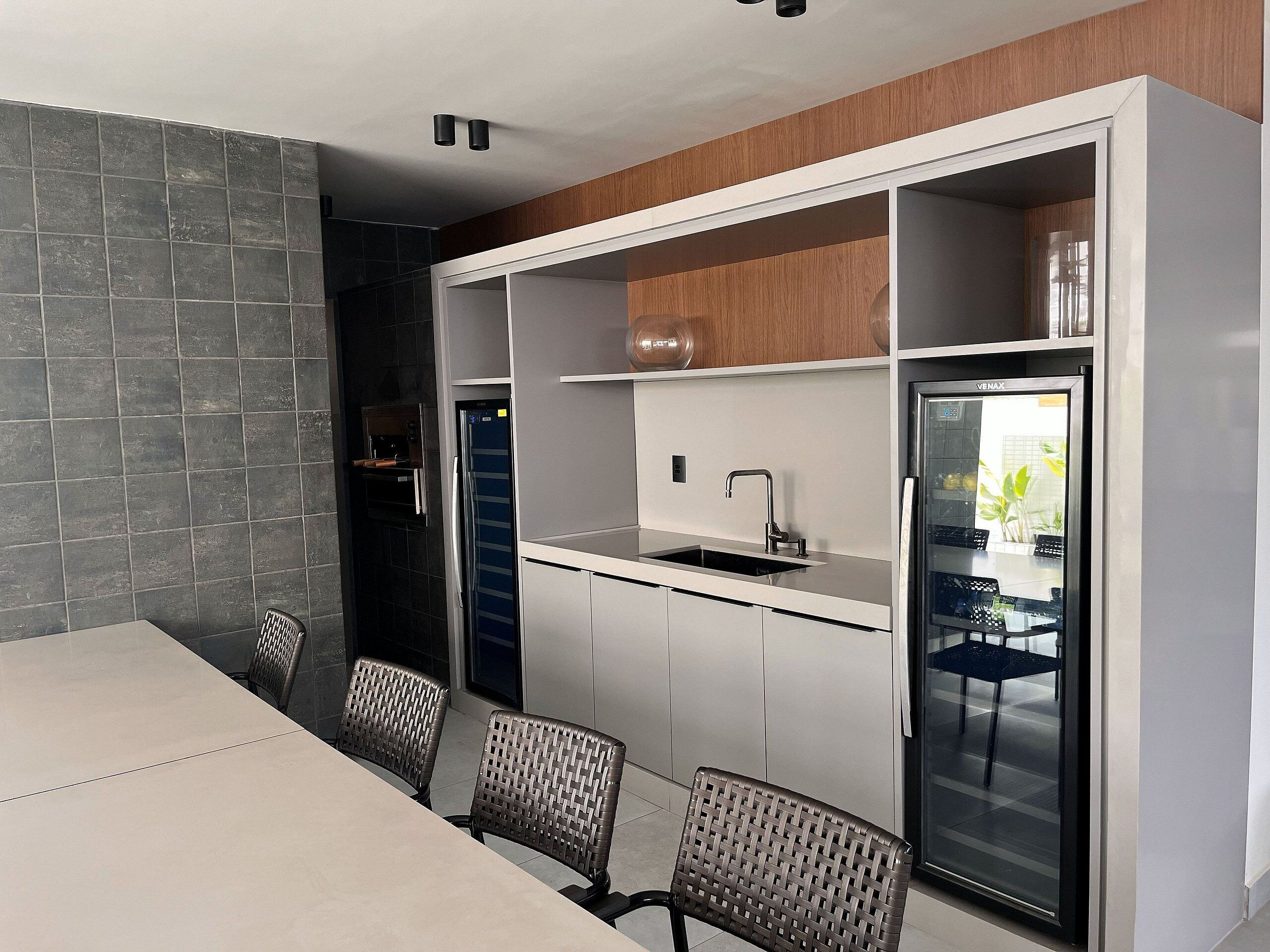 A modern kitchen with a built-in oven, a refrigerator, and a sink.